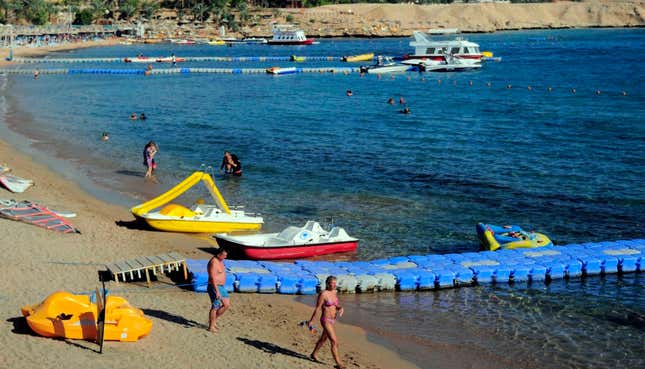 Tourists walk on a beach in Sharm el-Sheikh.
