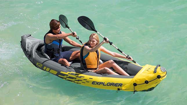 A man and a woman riding in the inflatable kayak on the water,