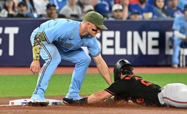 May 19, 2023; Toronto, Ontario, CAN;  Toronto Blue Jays third baseman Matt Chapman (26) tags out Baltimore Orioles right fielder Ryan McKenna (26) as he tried to advance from second on an errant pickoff throw in the second inning at Rogers Centre.