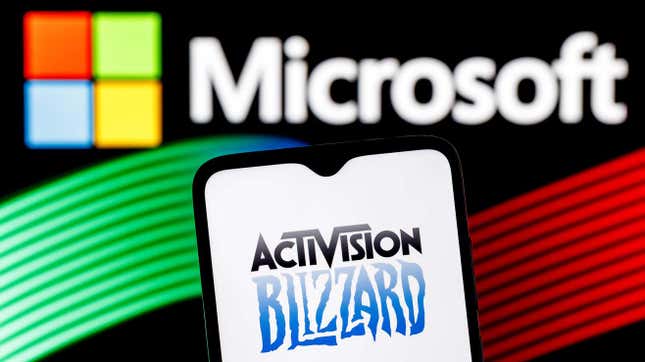El logotipo de Activision Blizzard en la pantalla de un móvil, con el logotipo de Microsoft de fondo.