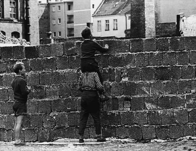Children peer over the wall into the eastern part of the city