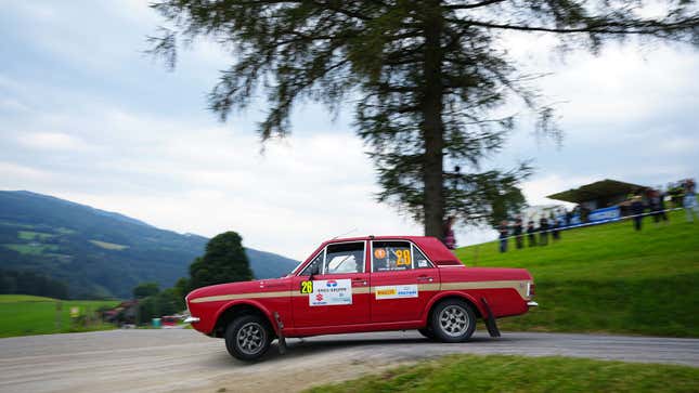 A photo of a vintage Ford Cortina running in a rally. 