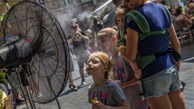 Girl stands in front of misting fan outside