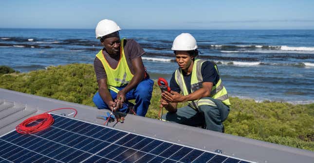 Workers testing out connectivity by a solar panel