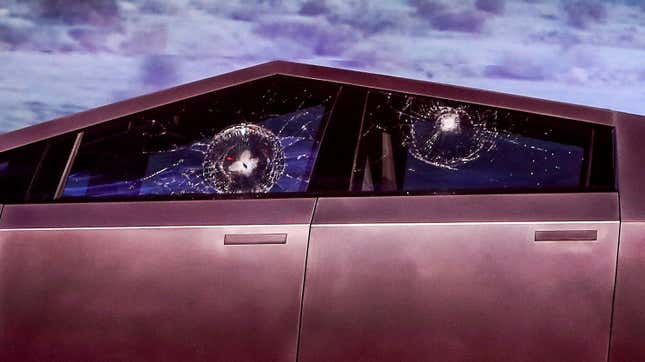 A photo of a Cybertruck with two broken windows.