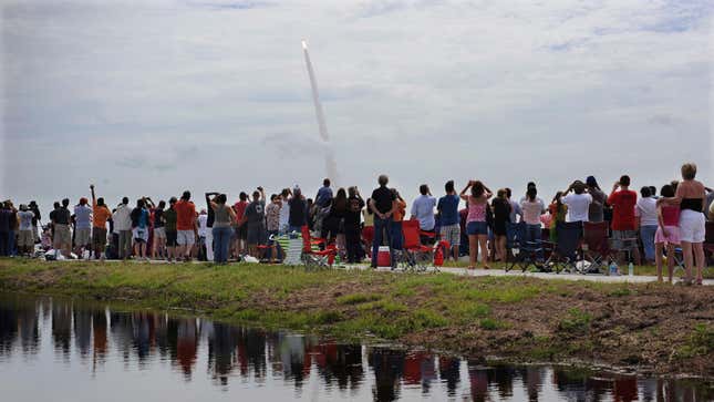 Spectators watch the Space Shuttle Atlantis blasting off on July 8, 2011. The launch was the 135th and final Space Shuttle launch for NASA. 