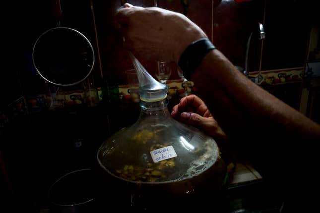 Esteves caps a jug of wine with a condom (AP Photo/Ramon Espinosa)