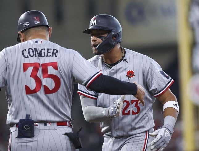 May 29, 2023; Houston, Texas, USA; Minnesota Twins third baseman Royce Lewis (23) reacts with first base/catching coach Hank Conger (35) after driving in a run with a single during the ninth inning against the Houston Astros at Minute Maid Park.