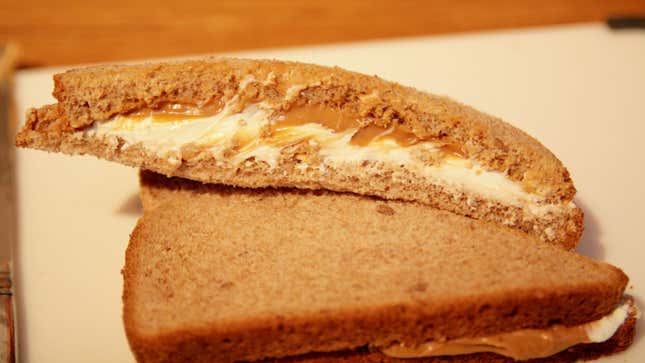 A cross-section of a sliced peanut butter and cream cheese sandwich