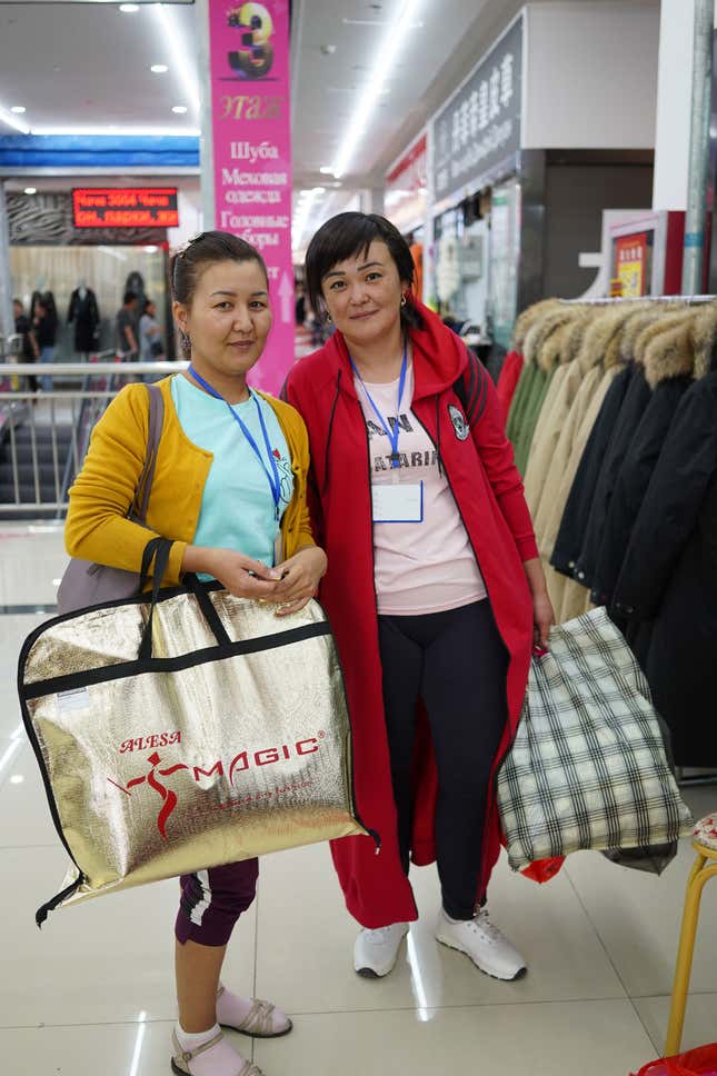 Saule Khasenovna and Balnur Isaevna stands in front of a fur coat store in Khorgos ICBC.