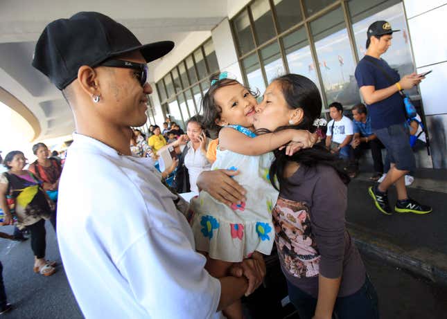 An OFW working in Qatar says goodbye to her family before boarding a flight in Manila, January 12, 2015.