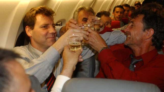 Men cheersing wine glasses on crowded plane