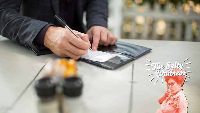 A businessman signs a restaurant check