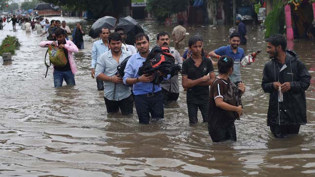 People wade through a flooded road on Sept. 04, after heavy rainfall in Mumbai.