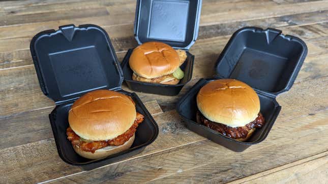 Three Wingstop Chicken Sandwiches in to-go containers on table