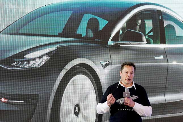Elon Musk in front of an image of a Tesla
