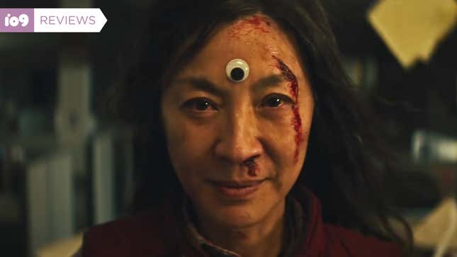 Michelle Yeoh wears a googly eye as her "third eye" and has a bloody face in a scene from Everything Everywhere All at Once.