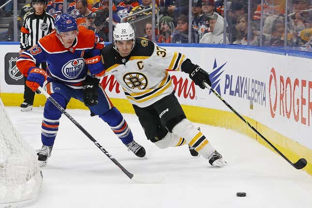 Feb 27, 2023; Edmonton, Alberta, CAN; Boston Bruins forward Patrice Bergeron (37) and Edmonton Oilers forward Ryan Nugent-Hopkins (93) battle for a loose puck during the second period at Rogers Place.