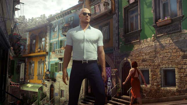 Agent 47 stands in an alleyway while wearing sunglasses. 
