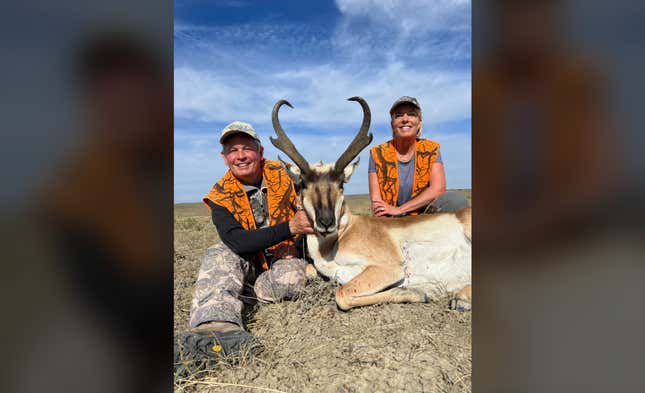 A photo of Steve Daines and his wife smiling next to a dead antelope with blood on its mouth.