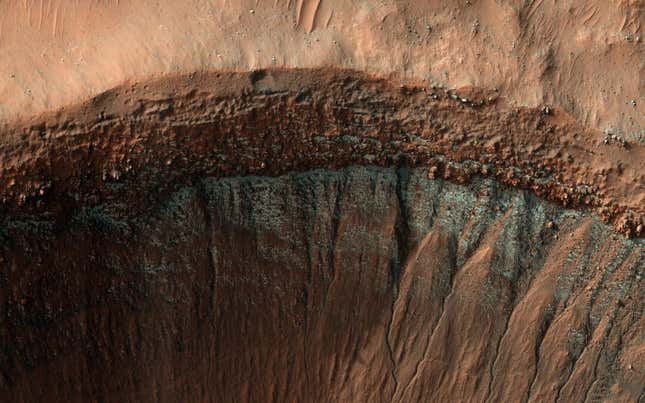 La cámara HiRISE capturó esta imagen del borde de un cráter en pleno invierno. En la pendiente del cráter que mira hacia el sur, que recibe menos luz solar, se ha formado una capa de escarcha.