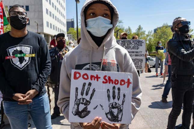 Black Lives Matter activist wears a hoodie and holds a sign with their hands that reads Don’t Shoot during a rally against police brutality in front of the Columbus City Hall in Columbus, Ohio, on May 1, 2021.