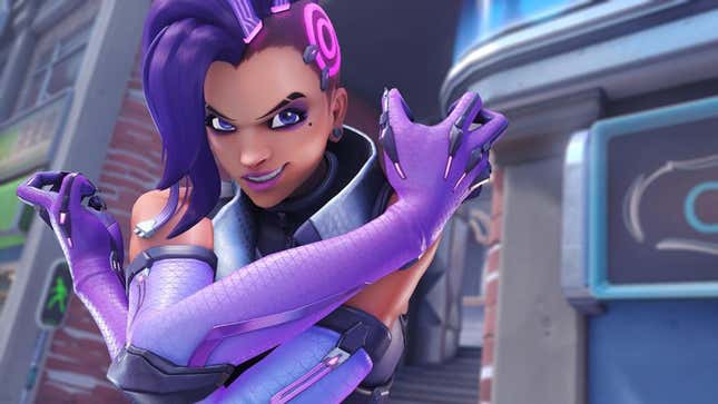 Overwatch's hacker Sombra, smiling into the camera with her arms crossed and her hands in claws. 