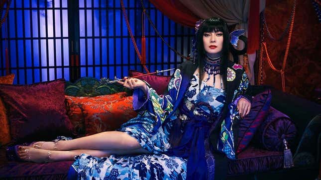 Ko Shibasaki is dressed in full-costume for the xxxHolic movie, sitting on a sofa and smoking a pipe. 