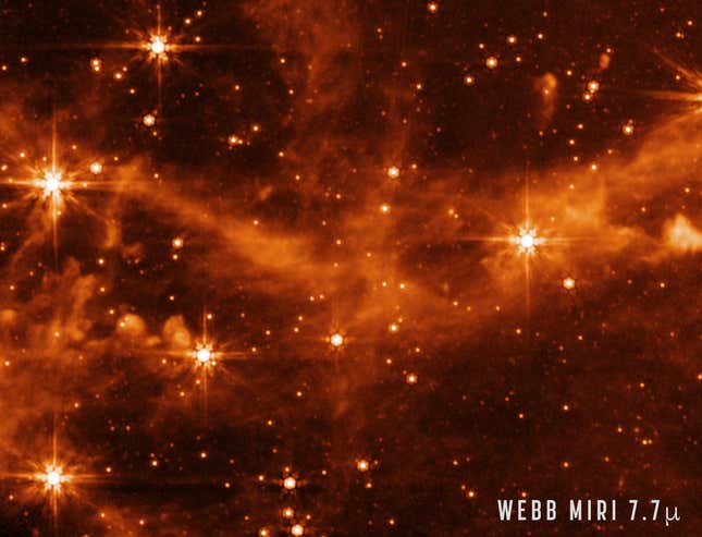 Stars and a cloud-like galaxy imaged by Webb Space Telescope.