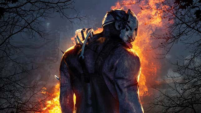 A scary, masked killer stands alone in the woods near a large fire. 