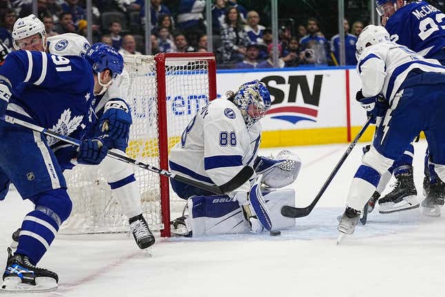 Apr 18, 2023; Toronto, Ontario, CAN; Tampa Bay Lightning goaltender Andrei Vasilevskiy (88) tries to grab a hold of the puck as Toronto Maple Leafs forward John Tavares (91) closes in during the first period of game one of the first round of the 2023 Stanley Cup Playoffs at Scotiabank Arena.