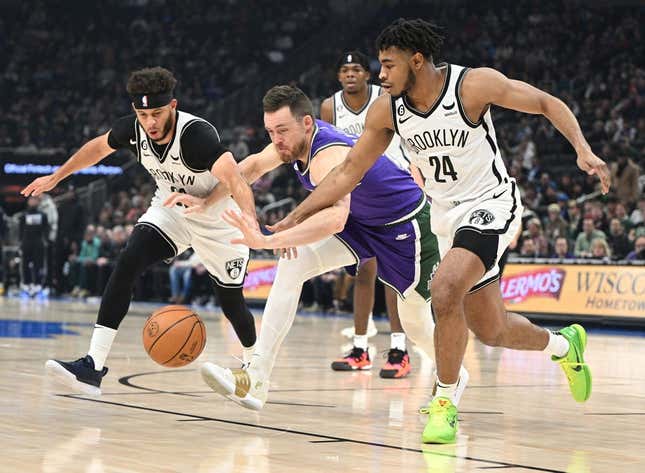 Mar 9, 2023; Milwaukee, Wisconsin, USA; Brooklyn Nets guards Seth Curry (30), left, and Cam Thomas (24) battle for the ball with Milwaukee Bucks guard Pat Connaughton (24) in the first half at Fiserv Forum.