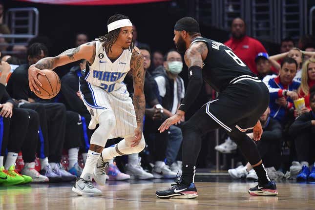 Mar 18, 2023; Los Angeles, California, USA; Orlando Magic guard Markelle Fultz (20) controls the ball against Los Angeles Clippers forward Marcus Morris Sr. (8) during the first half at Crypto.com Arena.