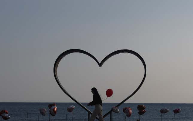 A woman walks past a heart shaped sculpture during Valentine's Day near Agios Theodoros village, Cyprus February 14, 2023.