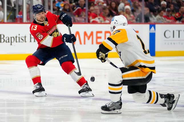 Mar 4, 2023; Sunrise, Florida, USA; Florida Panthers center Sam Reinhart (13) passes the puck against Pittsburgh Penguins right wing Bryan Rust (17) during the second period at FLA Live Arena.
