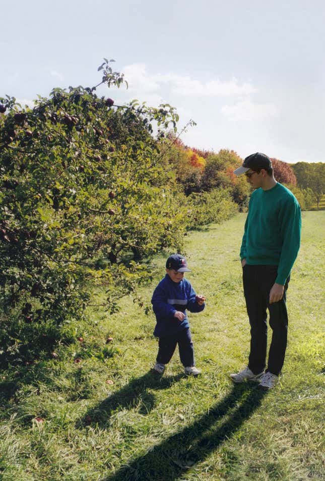 An older Nickerson watches his younger self picking apples at an orchard.