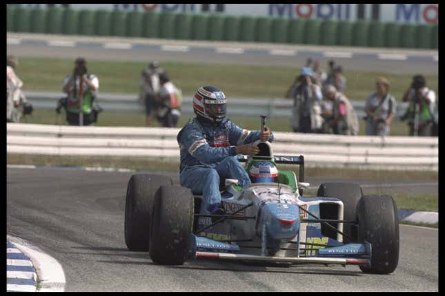 Gerhard Berger of Austria hitches a ride with Benetton teammate Jean Alesi of France during the 1996 German Grand Prix at Hockenheimring, Germany. 