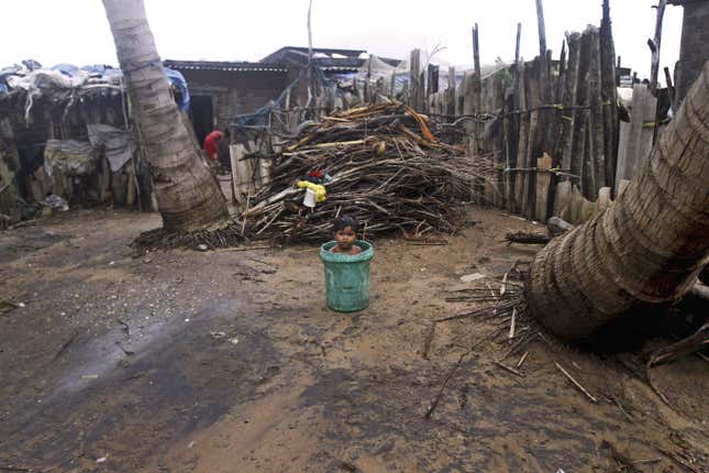 A child sits inside a plastic bucket near his house on the Bay of Bengal coast at Gopalpur, Orissa.