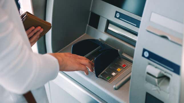 A photo showing someone's hands as they use an ATM