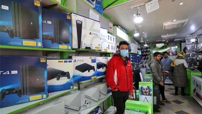 A retailer stands in front of PlayStation consoles. 