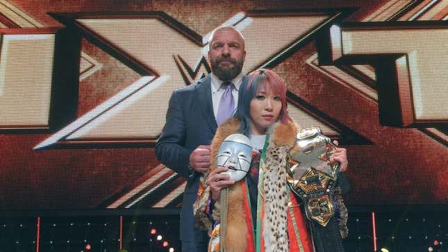 Asuka during her days as NXT champion, with Triple H