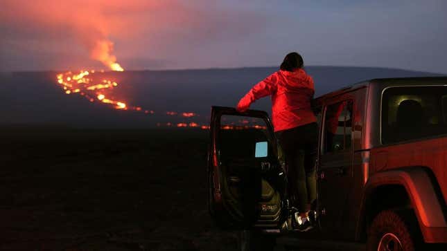 A woman watches the eruption of the Mauna Loa volcano on December 04, 2022 near Hilo, Hawaii.