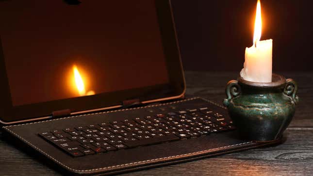 photo of a candle next to a powered-down computer