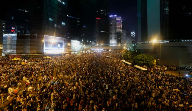 Tens of thousands of protesters block the main street to the Central financial district outside the government headquarters in Hong Kong, Sept. 28, 2014.