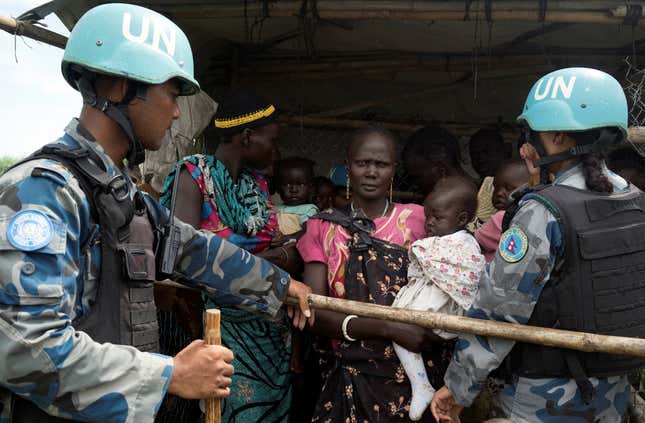 United Nations peacekeepers corral South Sudanese women and children before the distribution of emergency food supplies at a POC site in Juba.