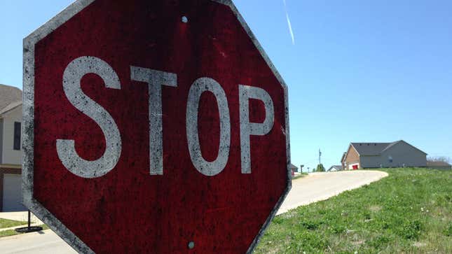 A photo shows a stop sign covered in black whiskey fungus.