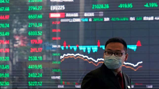 A man in a mask in front of a markets board.
