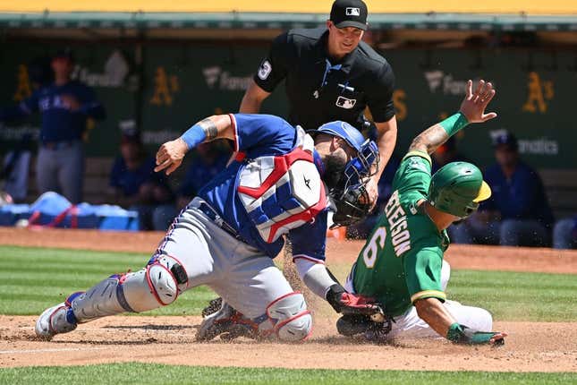 May 13, 2023; Oakland, California, USA; Texas Rangers catcher Sandy Leon (12) tags out Oakland Athletics infielder Jace Peterson (6) during the seventh inning at Oakland-Alameda County Coliseum.