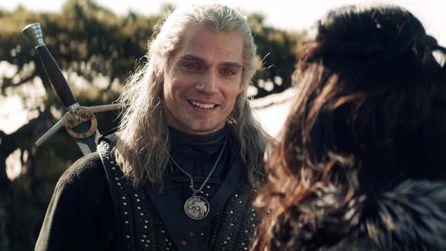 Henry Cavill as Geralt of Rivia in Netflix's The Witcher, smiling at Anya Chalotra's Yennefer. 