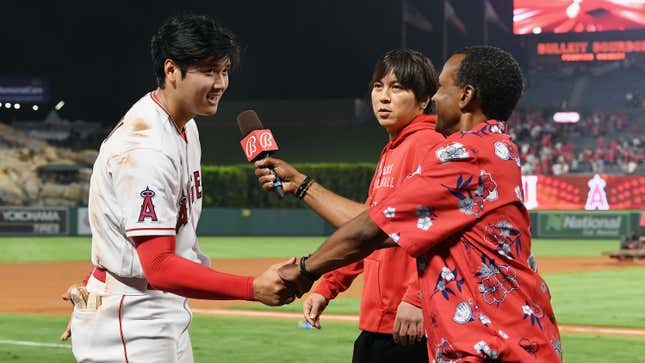 Los Angeles Angels P/DH Shohei Ohtani shakes hands with Bally Sports West analyst Jose Mota after a post-game interview.